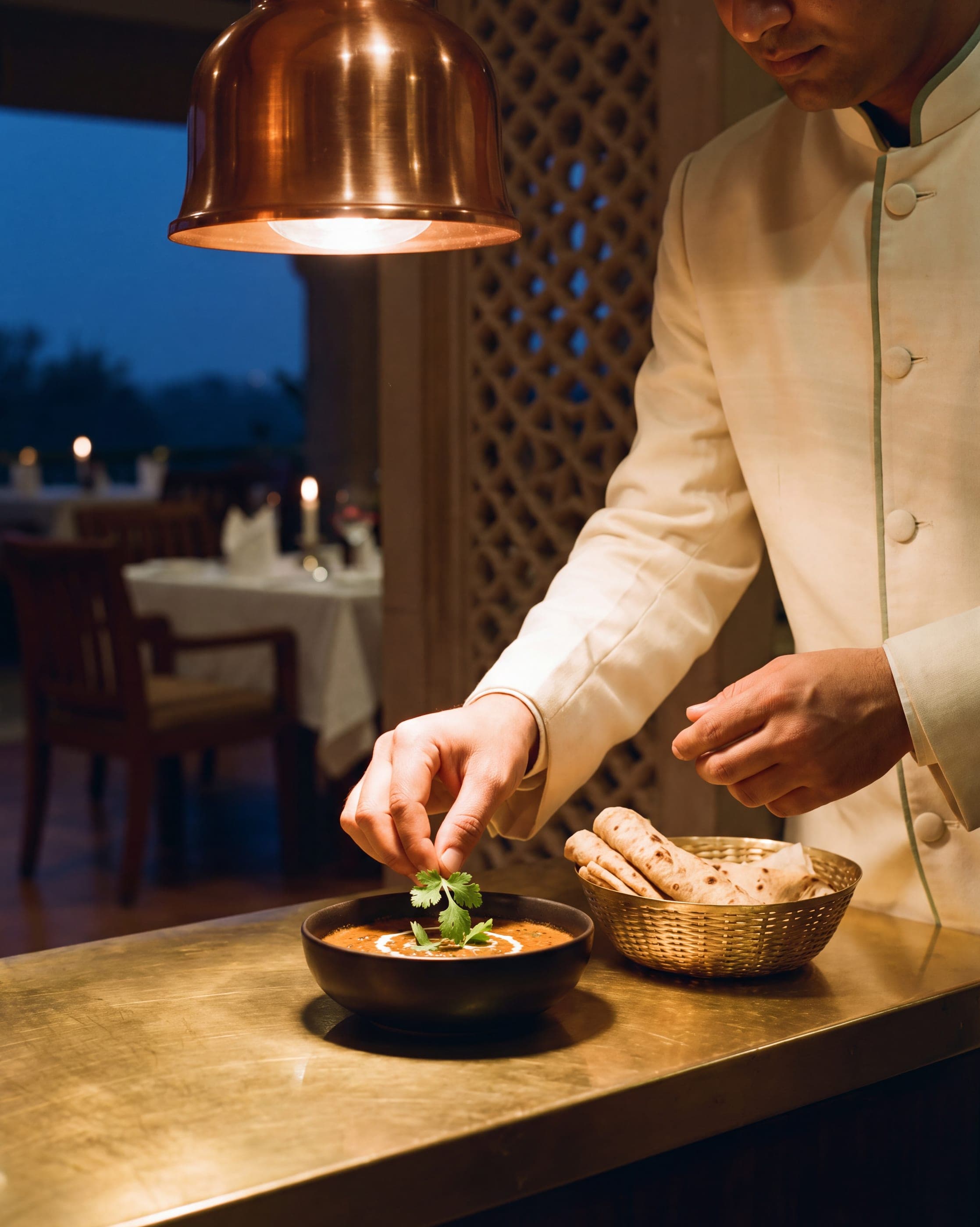 A chef finishing a late-night dish at the hotel kitchen pass